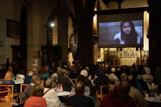 Visitors to the Keighley Creative Peace Meal watch the Ruth & Safiya film. Photo: Steve Rayner