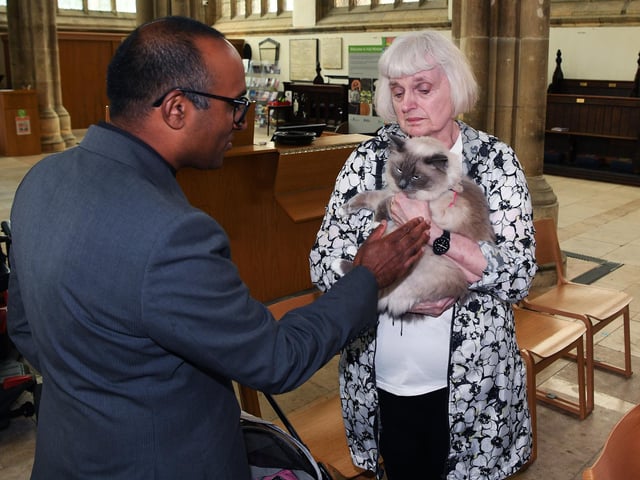 Revd Rob Sueka blesses a cat.