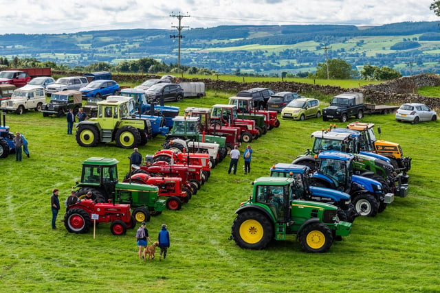 A mixture a vintage and new tractors on display