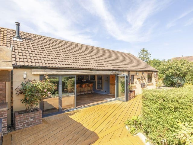 The substantial entertainment suite includes sliding doors opening onto the garden.
