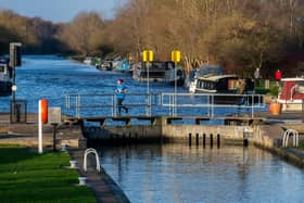 Date: 3rd January 2022.Picture James Hardisty.Weather Picture........A runner crosses over one of the lock gates of the Aire & Calder Navigationat Woodlesdford Lock, Leeds.