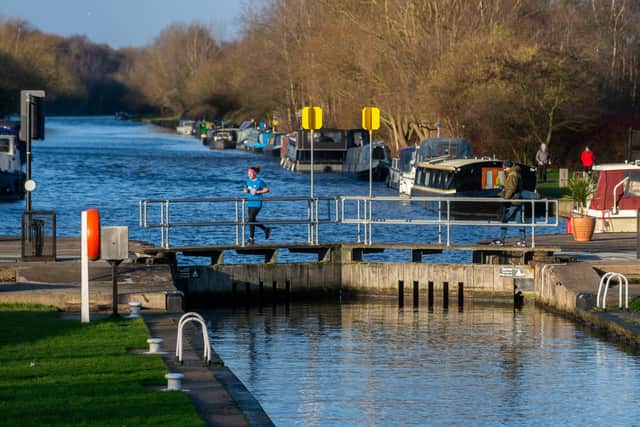 Date: 3rd January 2022.
Picture James Hardisty.
Weather Picture........A runner crosses over one of the lock gates of the Aire & Calder Navigation
at Woodlesdford Lock, Leeds.