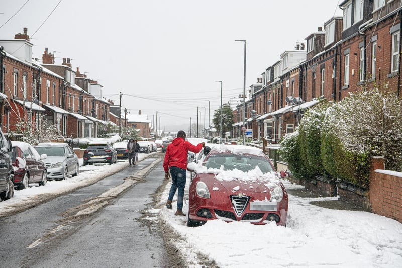 A commuter clears his car in Beeston, Leeds after heavy snowfall hit Yorkshire again overnight.