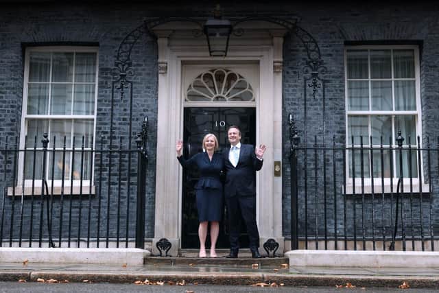 Standing outside 10 Downing Street, Britain's newly appointed Prime Minister Liz Truss poses for photographers with her husband Hugh O'Leary after delivering her first speech as Prime Minister in central London, on September 6, 2022. - Liz Truss on Tuesday officially became Britain's new prime minister, at an audience with head of state Queen Elizabeth II after the resignation of Boris Johnson. The former foreign secretary, 47, was seen in an official photograph shaking hands with the monarch to accept her offer to form a new government and become the 15th prime minister of her 70-year reign. (Photo by Adrian DENNIS / AFP) (Photo by ADRIAN DENNIS/AFP via Getty Images)