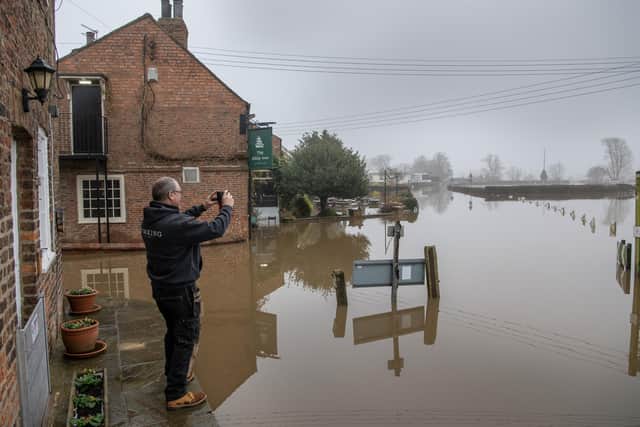 A member of the public looks at the flooding by The Ship Inn at Acaster Malbis near York where the River Ouse breached its banks