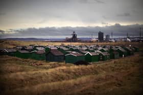 The iconic green fishermen's huts on South Gare with the Redcar blast furnace before its recent demolition.