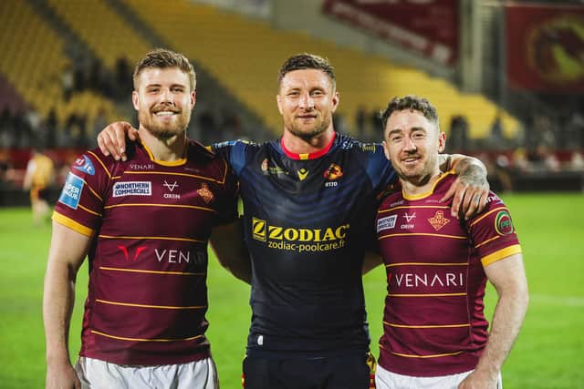 All smiles: Huddersfield's Jack Murchie, Tariq Sims & Adam Clune after beating Catalans (Picture by Rémi Vignaud/Catalans Dragons/SWpix.com)