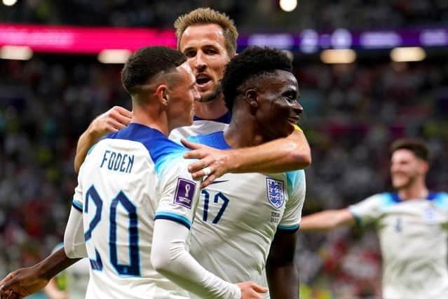 England's Bukayo Saka (right) celebrates with team-mates Phil Foden and Harry Kane after scoring their side's third goal of the game against Senegal at the Al-Bayt Stadium on Sunday. Picture: Martin Rickett/PA