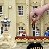 Library image of model maker Daniel Anderson from the Legoland Windsor Resort, placing a Lego model of King Charles III onto the balcony of Buckingham Palace as part of a coronation miniland scene,  before the coronation of King Charles III. (Photo by PA Wire/PA Images)