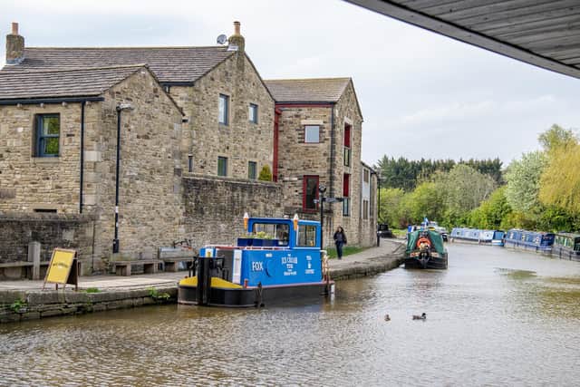 Caroline Hewes with her dog Roo on the Ice Cream Tug Boat moored in Skipton photographed for The Yorkshire Post by Tony Johnson. This is the tenth year of trading on the boat in the North Yorkshire town.   4th May 2023