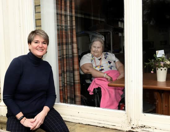 Elizabeth Hancock (L), Manager of Fulford Nursing Home with resident Julia behind the window .