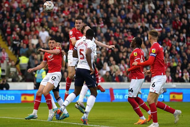 Liam Kitching rises highest to score the opening goal at Oakwell against Bolton. (Picture: PA)