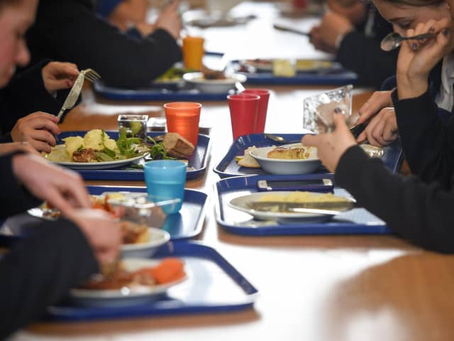Students eating their school dinner from trays and plates during lunch in the canteen. PIC: Ben Birchall/PA Wire