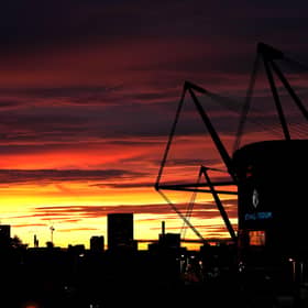 A general view from outside the Etihad Stadium with the sun setting in the background. PIC: Martin Rickett/PA Wire