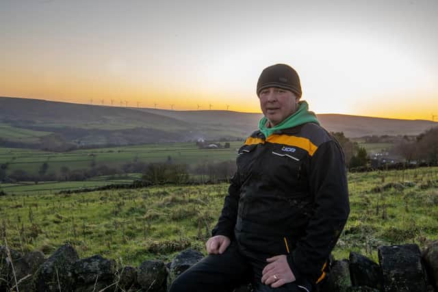 Jonathan Stansfield at Staups Lea Farm near Todmorden with Crook Hill wind turbines