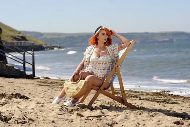 Woman in vintage clothing sitting on a beach in Whitby. (Pic credit: Simon Hulme)