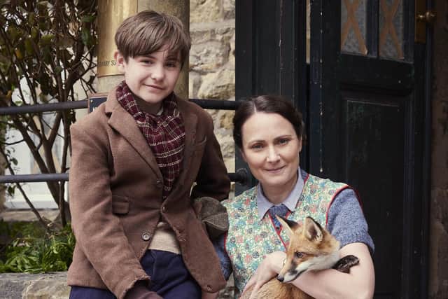 Christopher Taylor (Owen Phillips) and Mrs Hall (Anna Madeley) with a fox cub in the All Creatures Great and Small Christmas Special. Channel 5/Playground