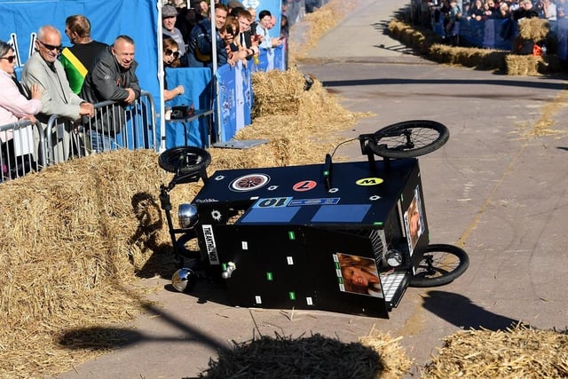 A soapbox cart crashes on its side during the race.