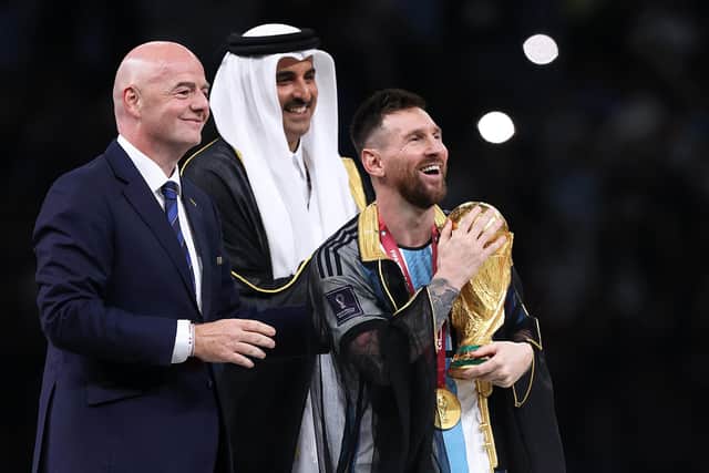 Lionel Messi of Argentina holds the FIFA World Cup Qatar 2022 Winner's Trophy as he interacts with Gianni Infantino, President of FIFA, and Sheikh Tamim bin Hamad Al Thani, Emir of Qatar, during the FIFA World Cup Qatar 2022 final (Picture: Julian Finney/Getty Images)