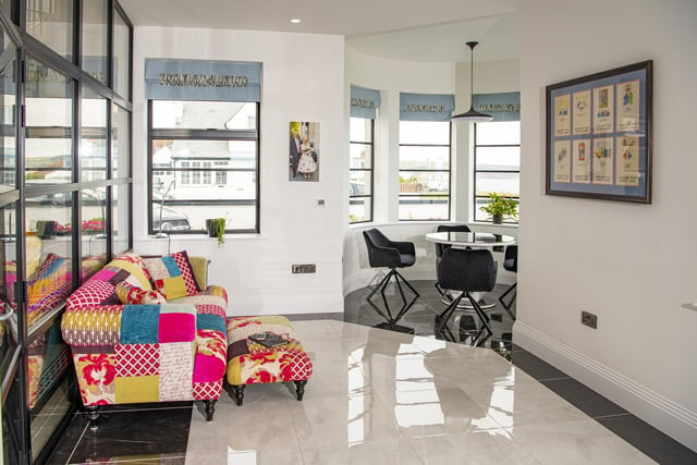 This space on the ground floor linking to the dining room is brightened by a colourful sofa