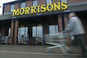 A shopper pushes his cart outside a Morrisons supermarket