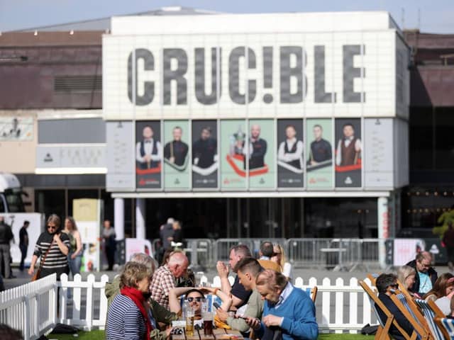 People enjoy the sunny weather outside the Crucible Theatre during day thirteen of the Cazoo World Snooker Championship at Crucible Theatre. (Photo by George Wood/Getty Images)
