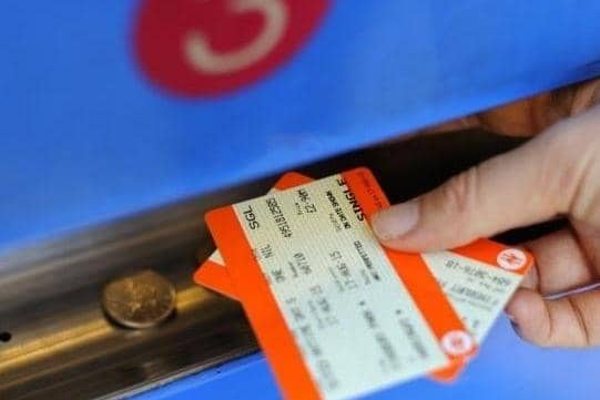 A customer collecting rail tickets from a ticket machine.