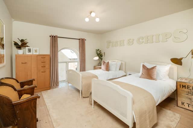 A twin bedroom with the vintage Fish and Chips sign and vintage cinema seats