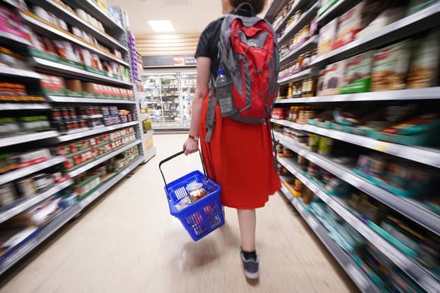 A shopper walking through the aisle of a supermarket. PIC: Yui Mok/PA Wire