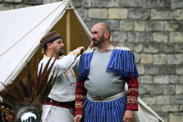 A man getting dressed up in his Roman costume.