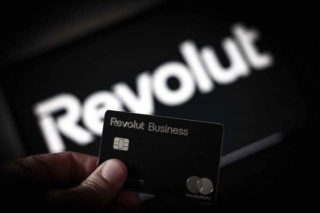 An illustration shows a person holding a Revolut Business credit card in Paris on May 21, 2025. (Photo by Thibaud MORITZ / AFP)