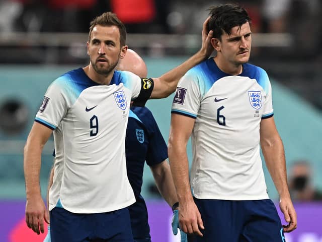 England's forward #09 Harry Kane (L) gestures to his teammate defender #06 Harry Maguire during the Qatar 2022 World Cup Group B football match between England and Iran at the Khalifa International Stadium in Doha on November 21, 2022. (Photo by PAUL ELLIS/AFP via Getty Images)