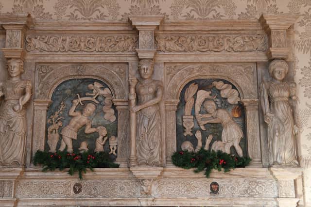 A close up of the overmantles on the soap stone fireplace in the dining room depicting scenes from the Old Testament