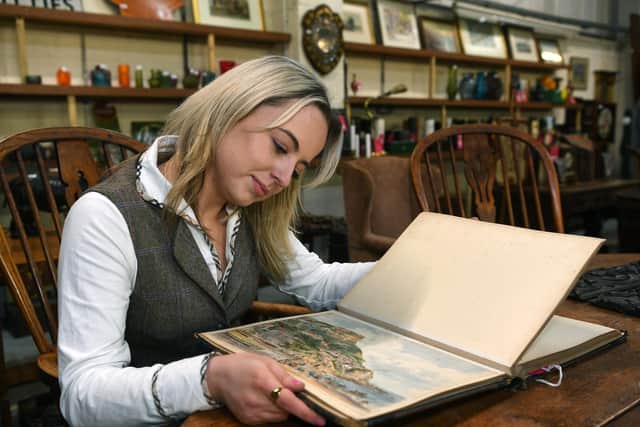 Eleanor Williams looking through an extensive sketch book containing 98 individual studies in watercolour and pencil attributed to the ‘the Turner of the North’ George Weatherill, estimated at £5000 - £8000.