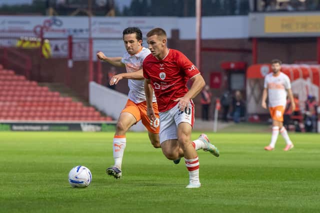 Barnsley's Jonathan Bland takes on Blackpool's George Honeyman. Photo: Tony Johnson.
