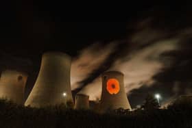 Library image of a poppy projected on to one of the ] cooling towers of Drax Power Station, near Selby in North Yorkshire