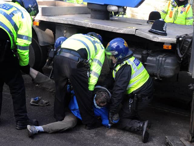 A protestor is forcefully removed from under a contractor's truck after stopping felling from taking place on Kenwood Road in Sheffield in March 2018. Picture Scott Merrylees