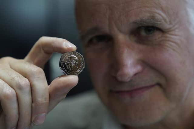 Artist Martin Jennings with one of the first coins featuring the portrait of King Charles III to be struck at The royal Mint in Pontyclun, ahead of them entering circulation from December 28, 2022.