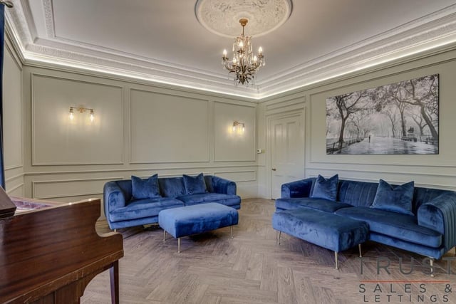 This reception room features panelling, a piano and seating
