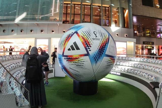 HOST COUNTRY: A traveller stands next to a giant football in the new central concourse building at the Hamad International Airport
