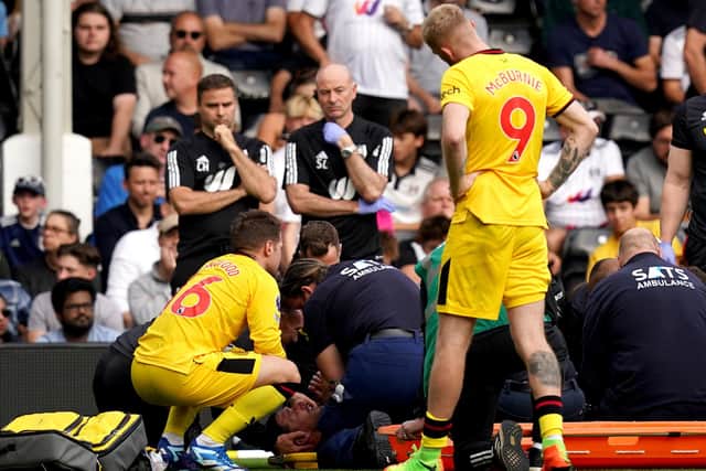 Concern: Sheffield United's Chris Basham, bottom, receives treatment as concerned team-mates look on during the defeat at Fulham (Picture: PA)