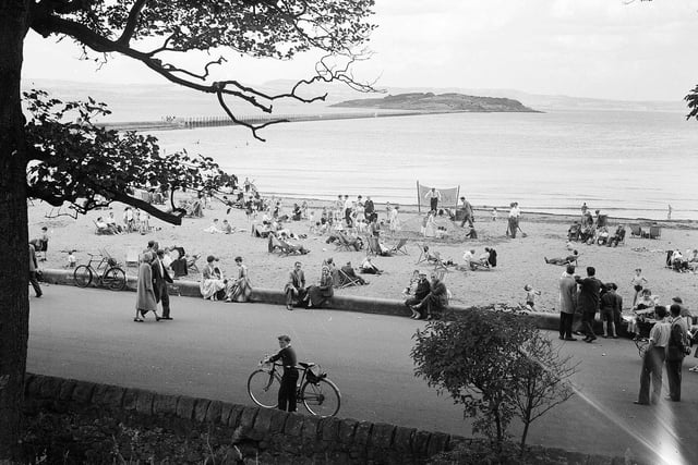 A view of holidaymakers enjoying the Cramond Promenade and beach, with Cramond Island in the background, in September 1958.