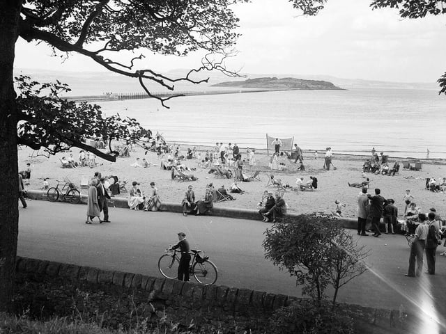 A view of holidaymakers enjoying the Cramond Promenade and beach, with Cramond Island in the background, in September 1958.