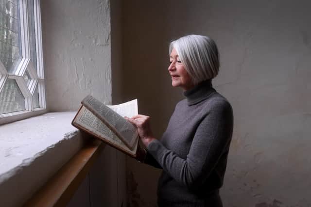 Ruth Hoffman is pictured with the Flood victims bible in the exhibition in the The Samuel Worth Chapel, Sheffield. Picture taken by Yorkshire Post Photographer Simon Hulme