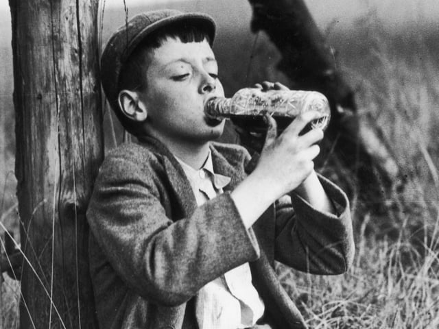 A young boy takes a break for a drink after picking blackberries in Yorkshire in 1942.
