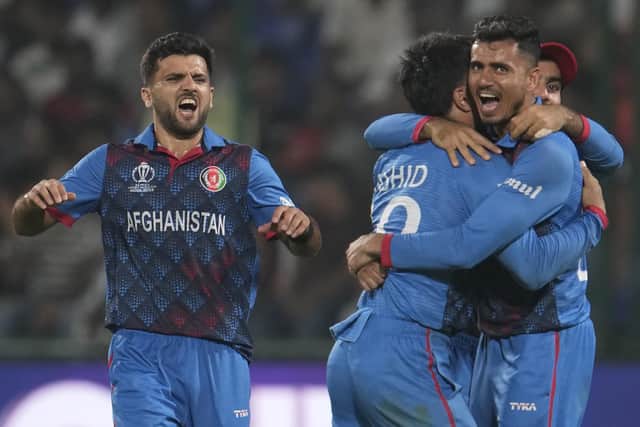 Afghanistan's Rashid Khan is hugged by team members as they celebrate the wicket of England's Adil Rashid in New Delhi Picture: AP Photo/Manish Swarup