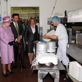 Queen Elizabeth II pictured with brother and sister Bill Riding and Tilly Carefoot watching the cheese making process during the royal visit to Singleton's Dairy in June 2008.
