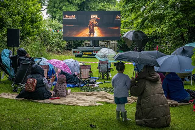 Families shelter under their umbrellas during a outdoor screening of Paddington Bear at a community picnic in the park at Burghwallis near Doncaster to celebrate the Queen's Platanum Jubilee earlier this year. PIC: Tony Johnson