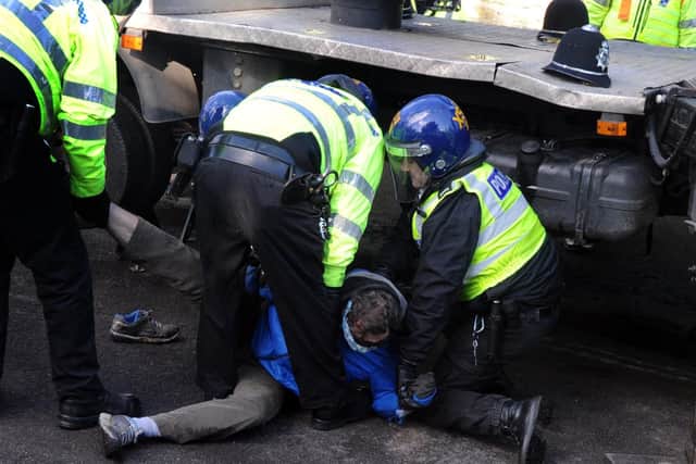 A protestor is forcefully removed from under a contractor's truck after stopping felling from taking place. PIC: Scott Merrylees