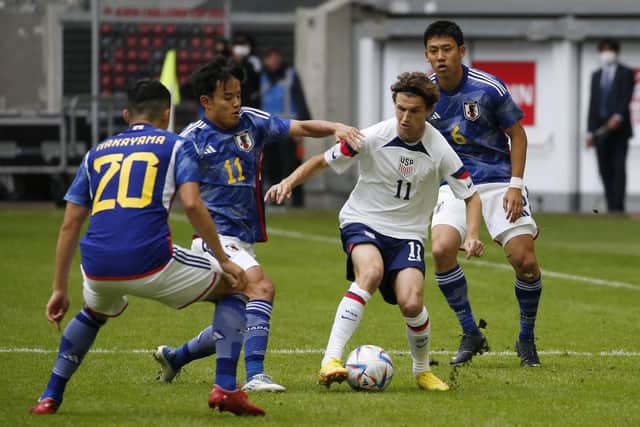 Huddersfield Town's Japan midfielder Yuta Nakayama, left, challenges Leeds United's USA midfielder Aaronson Brenden (second right) during the friendly football match between Japan and United States in Dusseldorf, western Germany, on September 23, 2022. (Photo by NORBERT SCHMIDT/AFP via Getty Images)